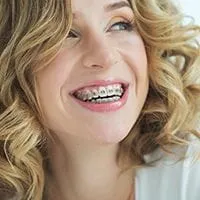 woman with short blond hair smiling looking right, braces on teeth, Orthodontics Melrose, MA