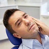 man holding jaw in pain, needs root canal Melrose, MA endodontist