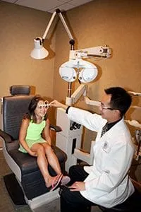 A child is getting her eyes examined by DR Gee