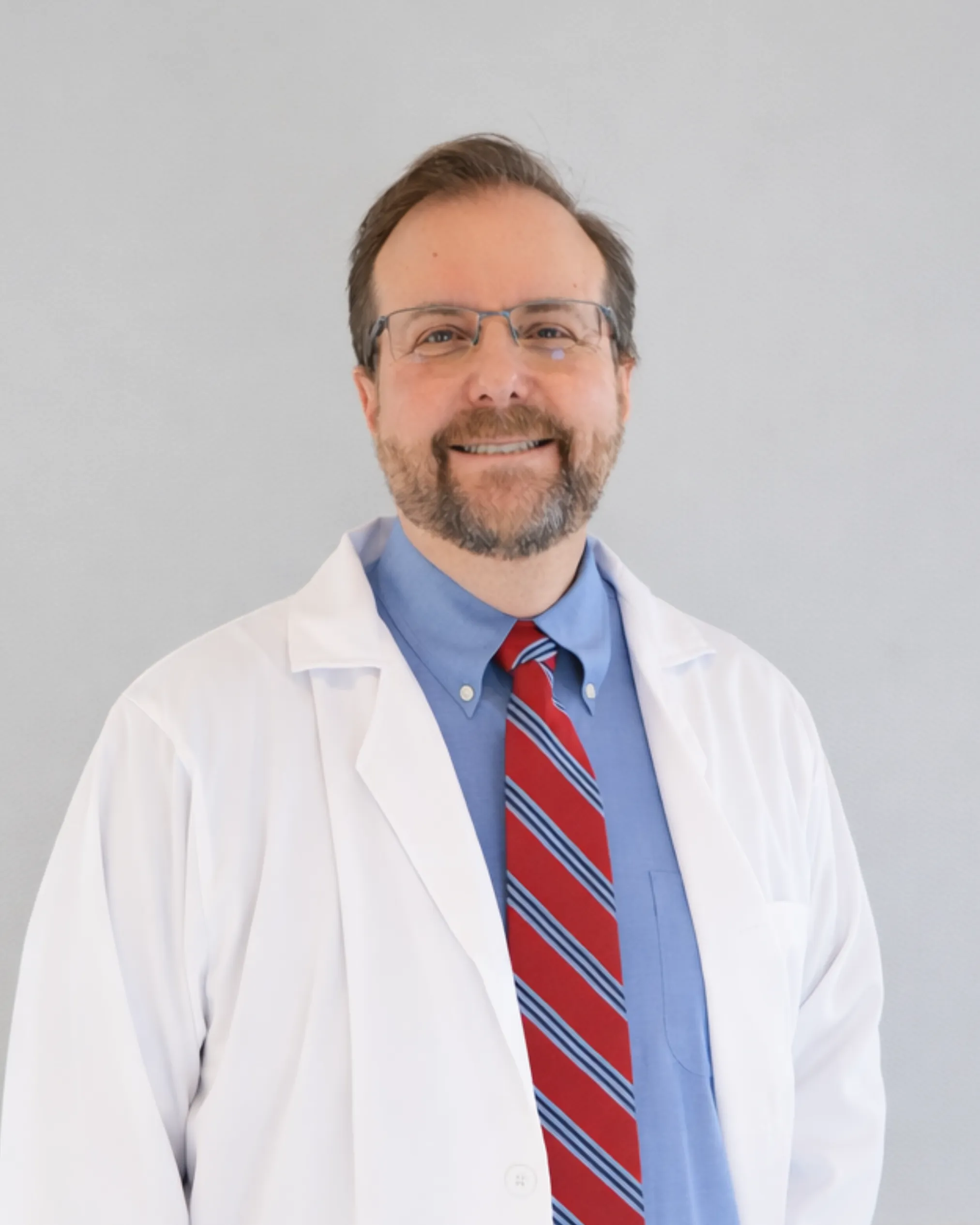 Dr. Matke headshot in white coat and business casual attire