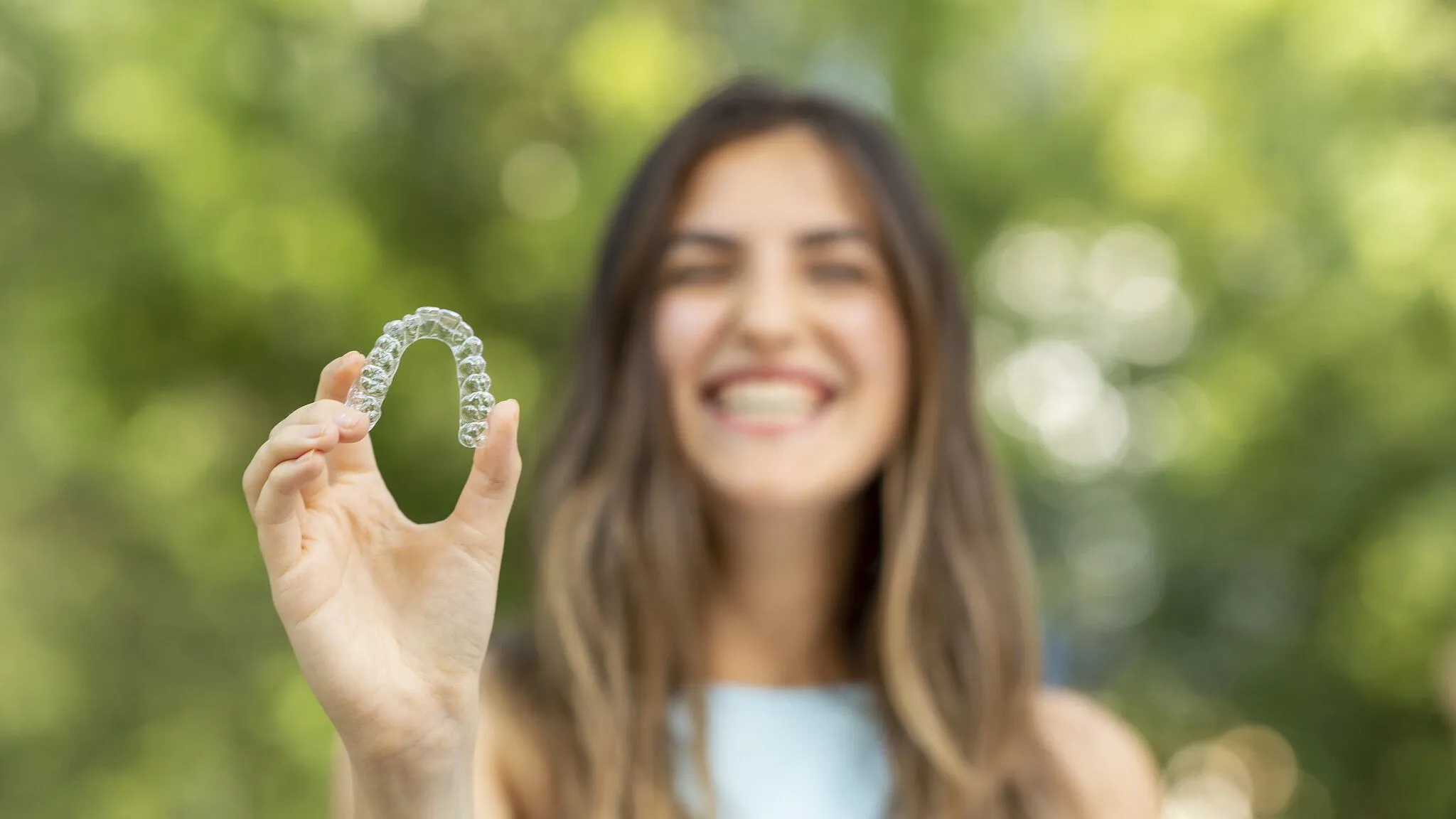 blurredphotoofgirlholdinginvisalign