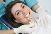 woman smiling in dental chair getting her teeth whitened. Cosmetic dentistry in Montgomery, AL