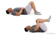 A man lies on his back and demonstrates pulling both knees to his chest to stretch for sciatic pain. 