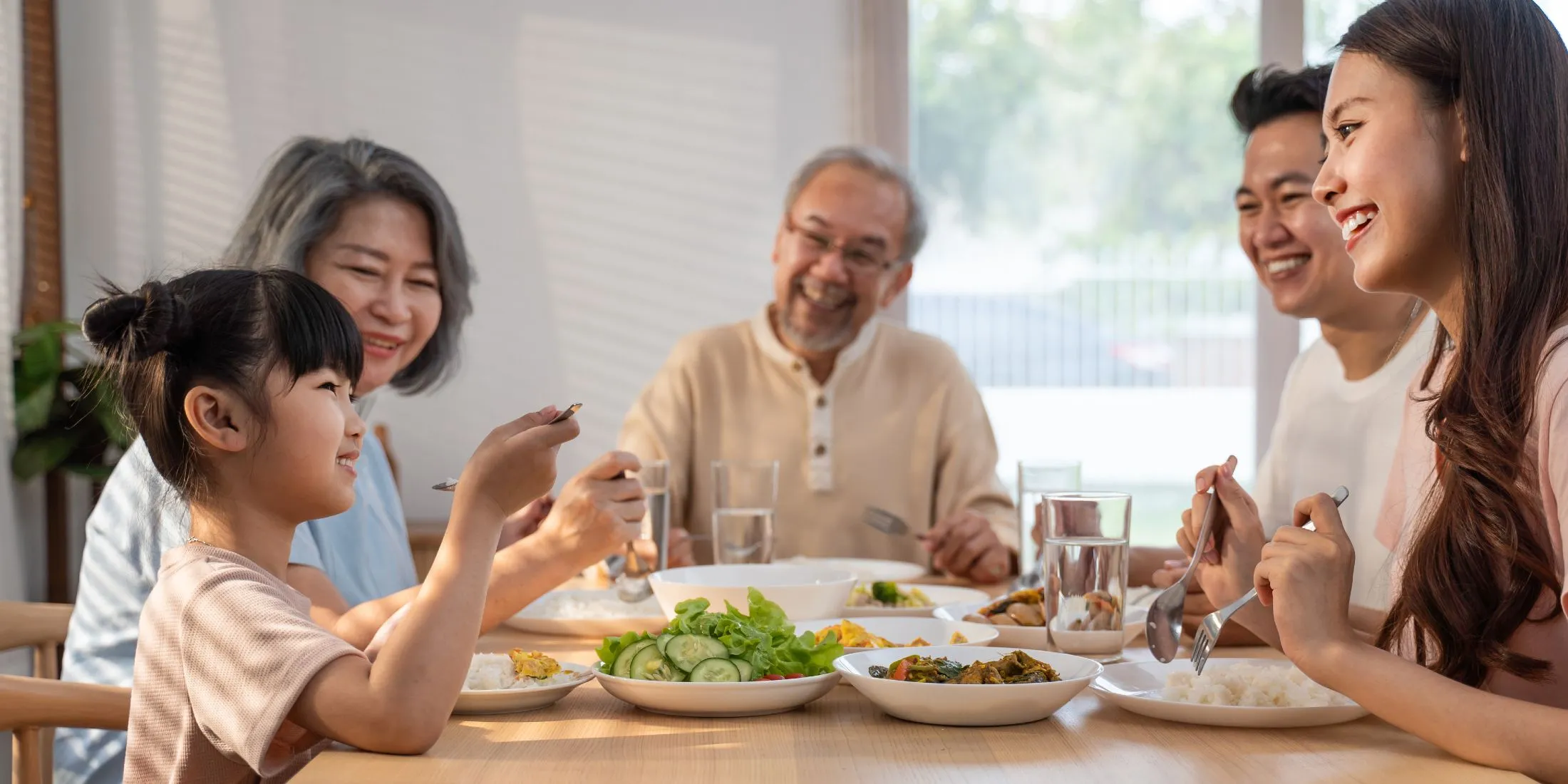 Family smiling and eating at dinner table