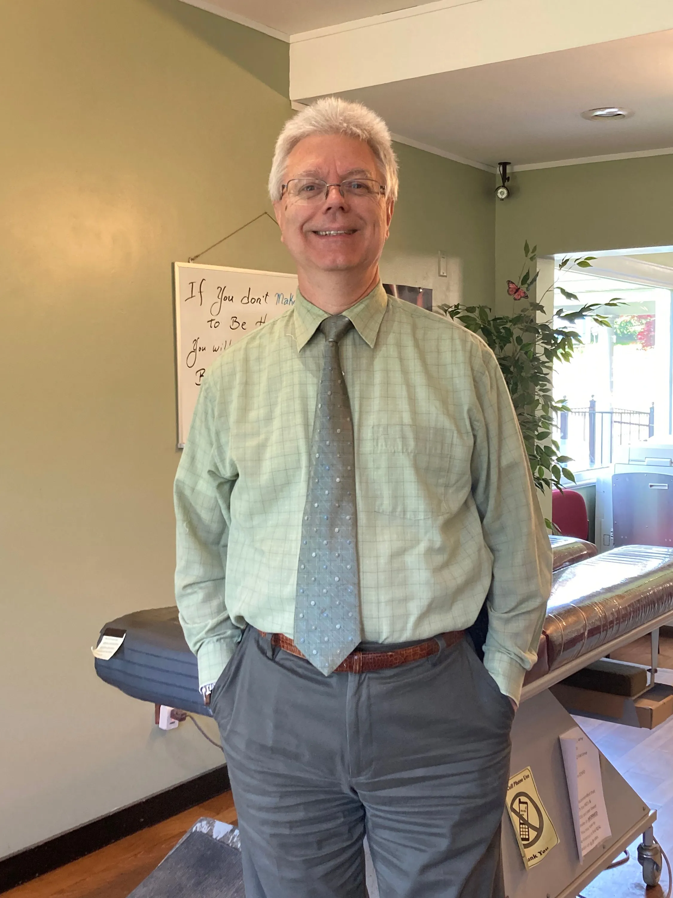 Dr. Kish smiles in front of an office adjusting table.