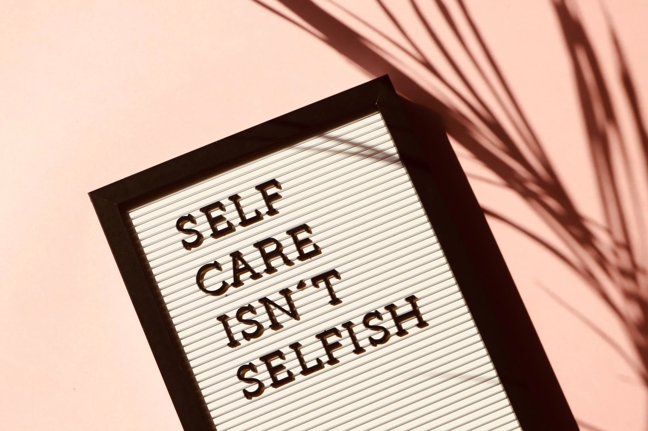 A framed black quote that says, "Self Care Isn't Selfish"