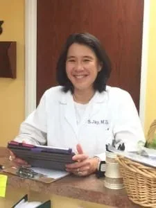 Dr. Jay smiling wearing a white coat