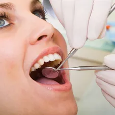 dentist examining inside woman's mouth