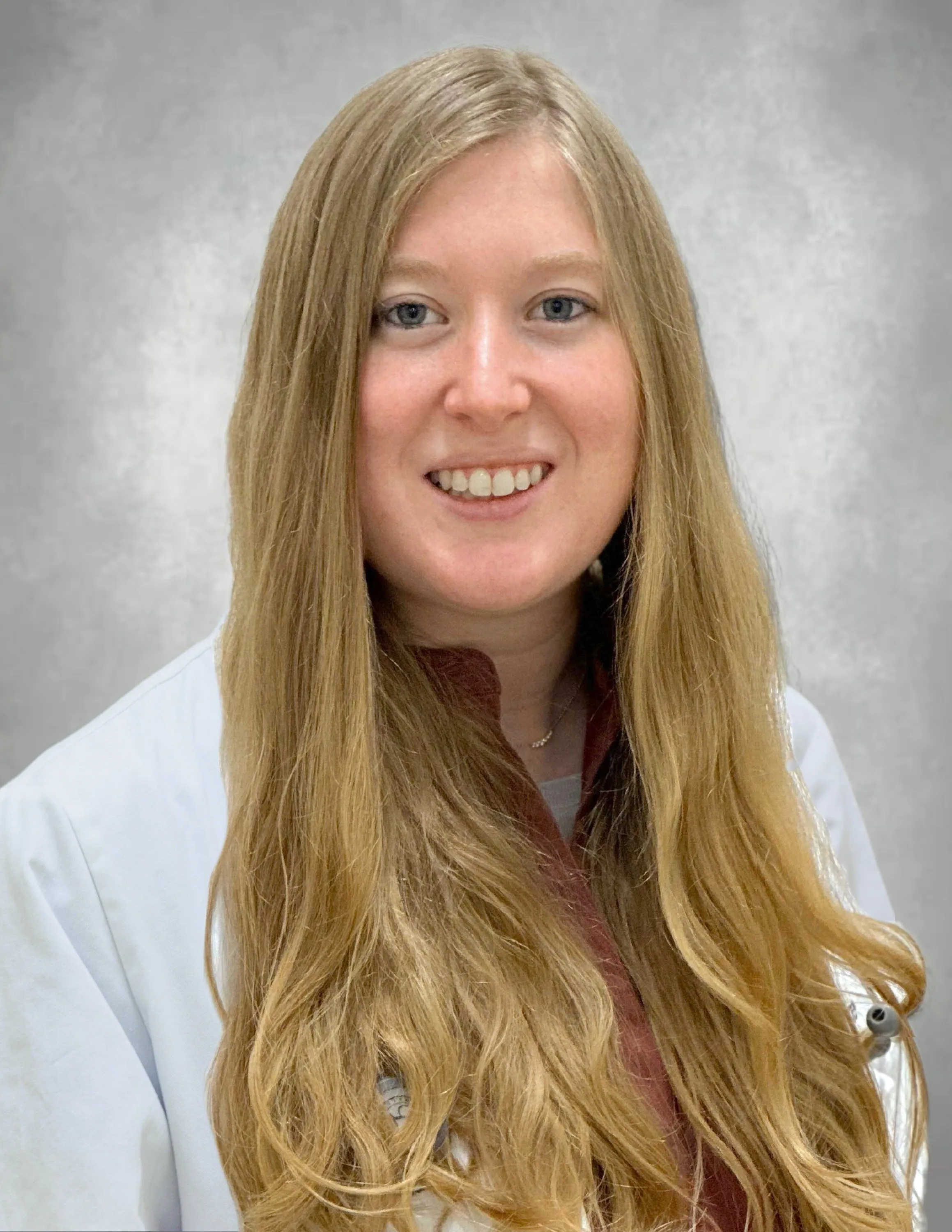 Dr. Hope smiling in her white lab coat