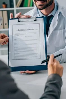 image of doctor showing insurance claim form to patient in clinic