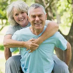 old couple outside smiling, posing. dentist Cypress, TX