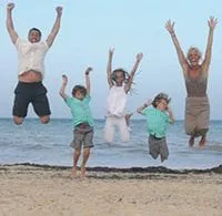 doctor limle's family on the beach jumping in the air 