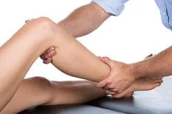 A Mans arm stretching a womans leg