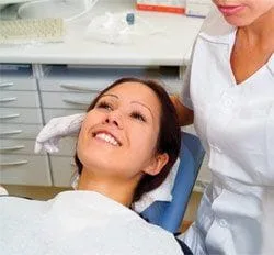 smiling woman lying back in dental exam chair for procedure, tooth extractions Placerville, CA dentist