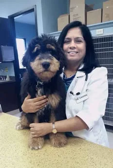 Dr. Sharmila Chinna hugging a dog.
