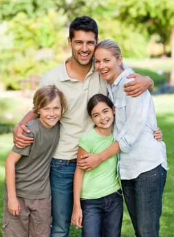 family outdoors hugging and smiling, Omaha, NE family dentistry Chalco, NE