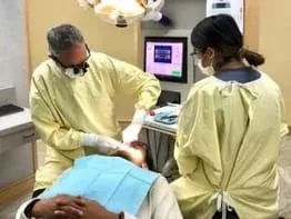 Dr. Warren and assistant doing dental work on patient, dental veneers Millbrae, CA