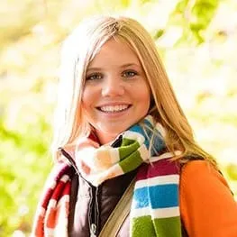 blond woman wearing scarf outdoors smiling, cosmetic dentistry Selmer, TN