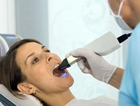 Woman getting her mouth scanned for a same day crown using CEREC in Marquette, MI