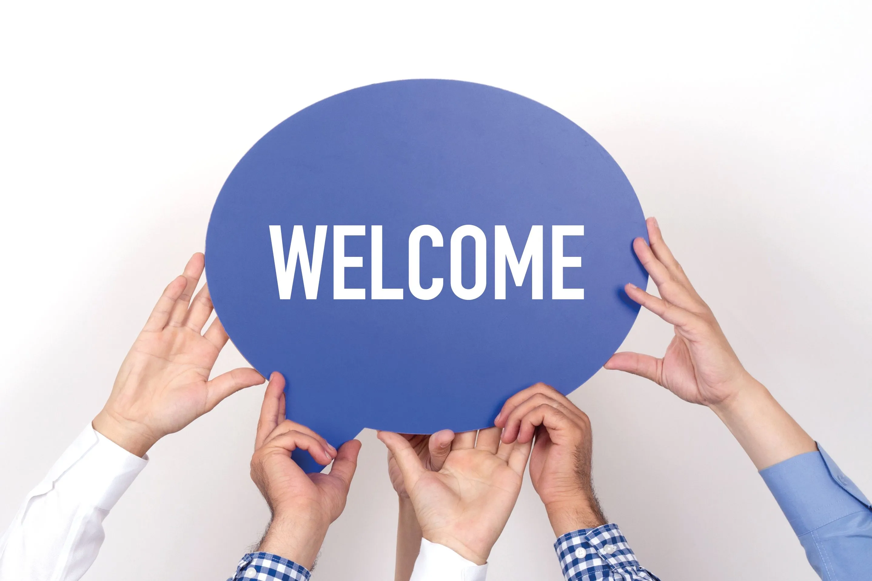 Group of people holding the WELCOME written speech bubble