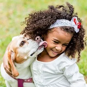 dog licking little girl on the chin