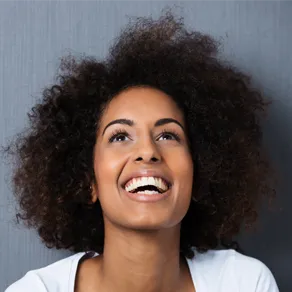 woman looking up smiling, nice teeth and dental crowns Brookline, MA