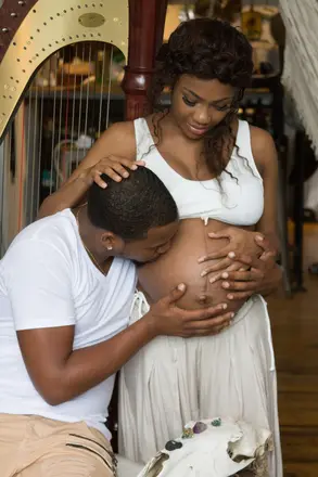 person kissing pregnant person's stomach