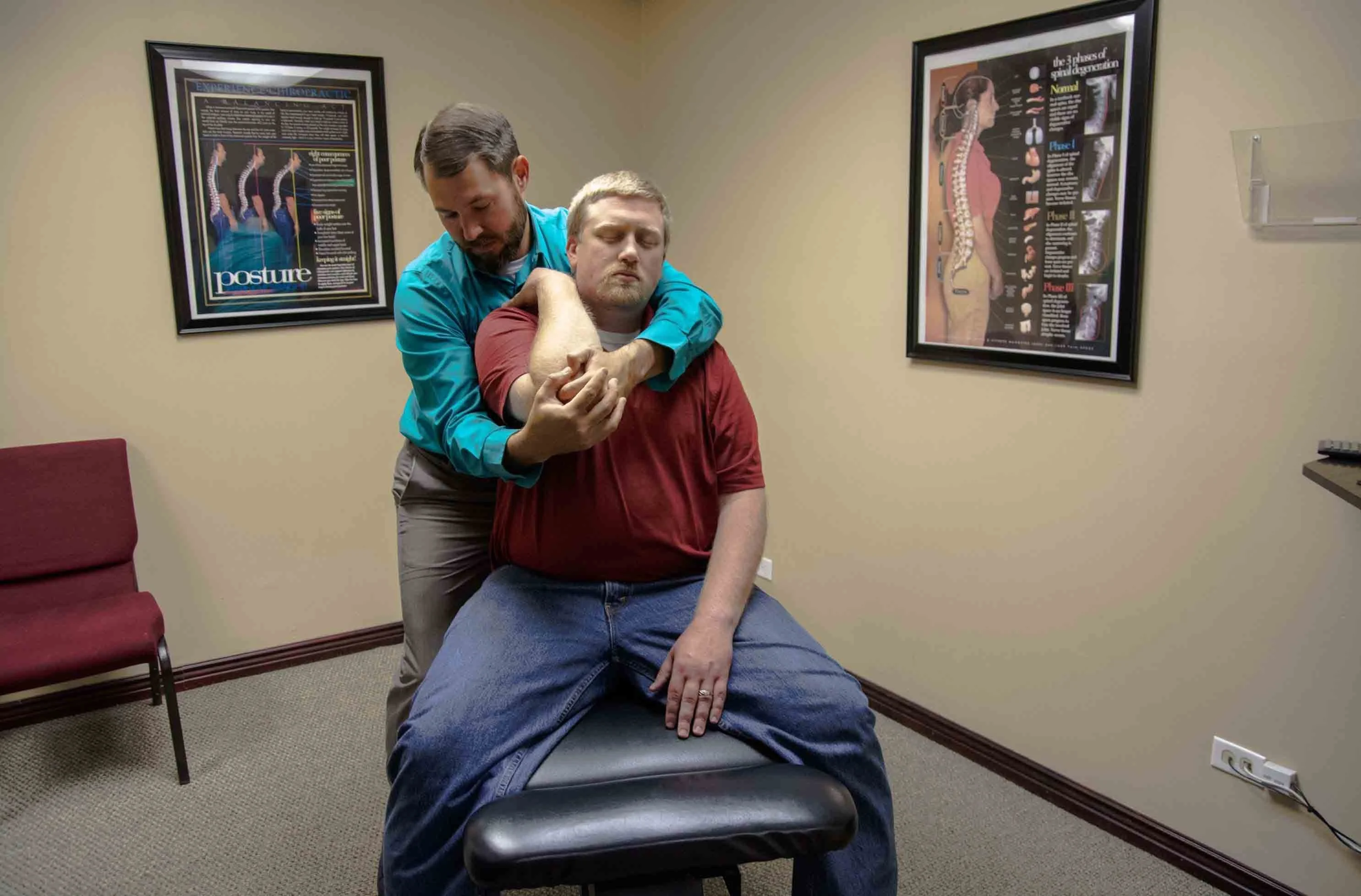 A chiropractor holding a man's elbow