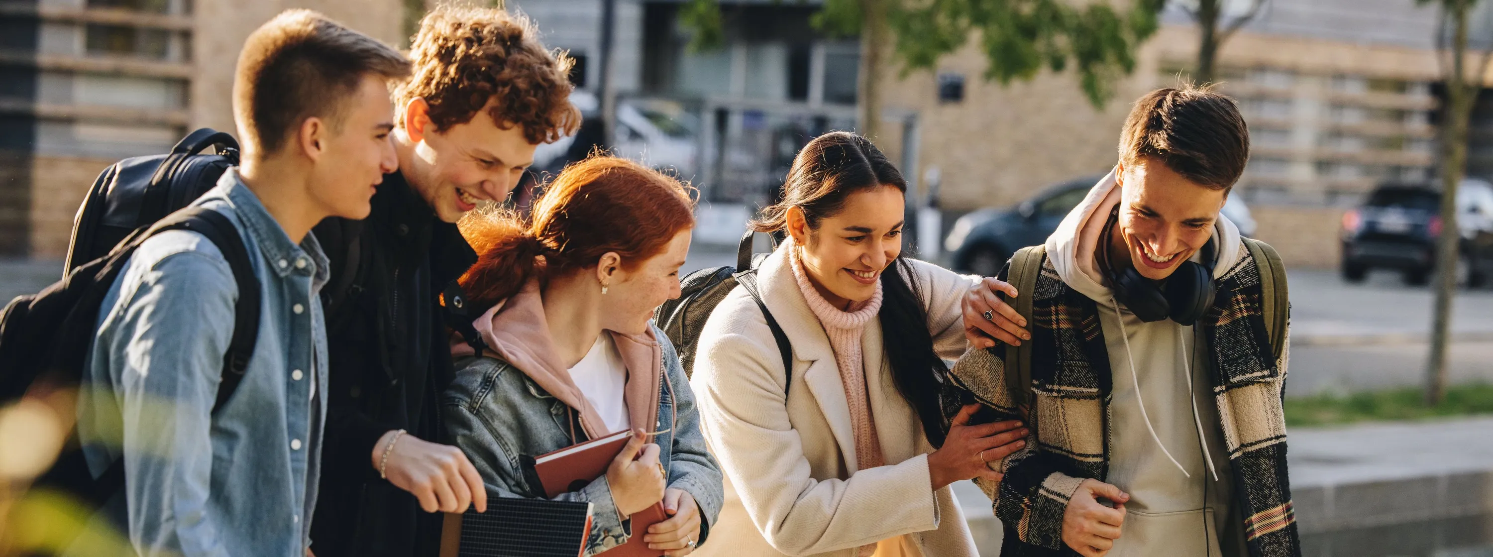 A group of happy teens outside of school.