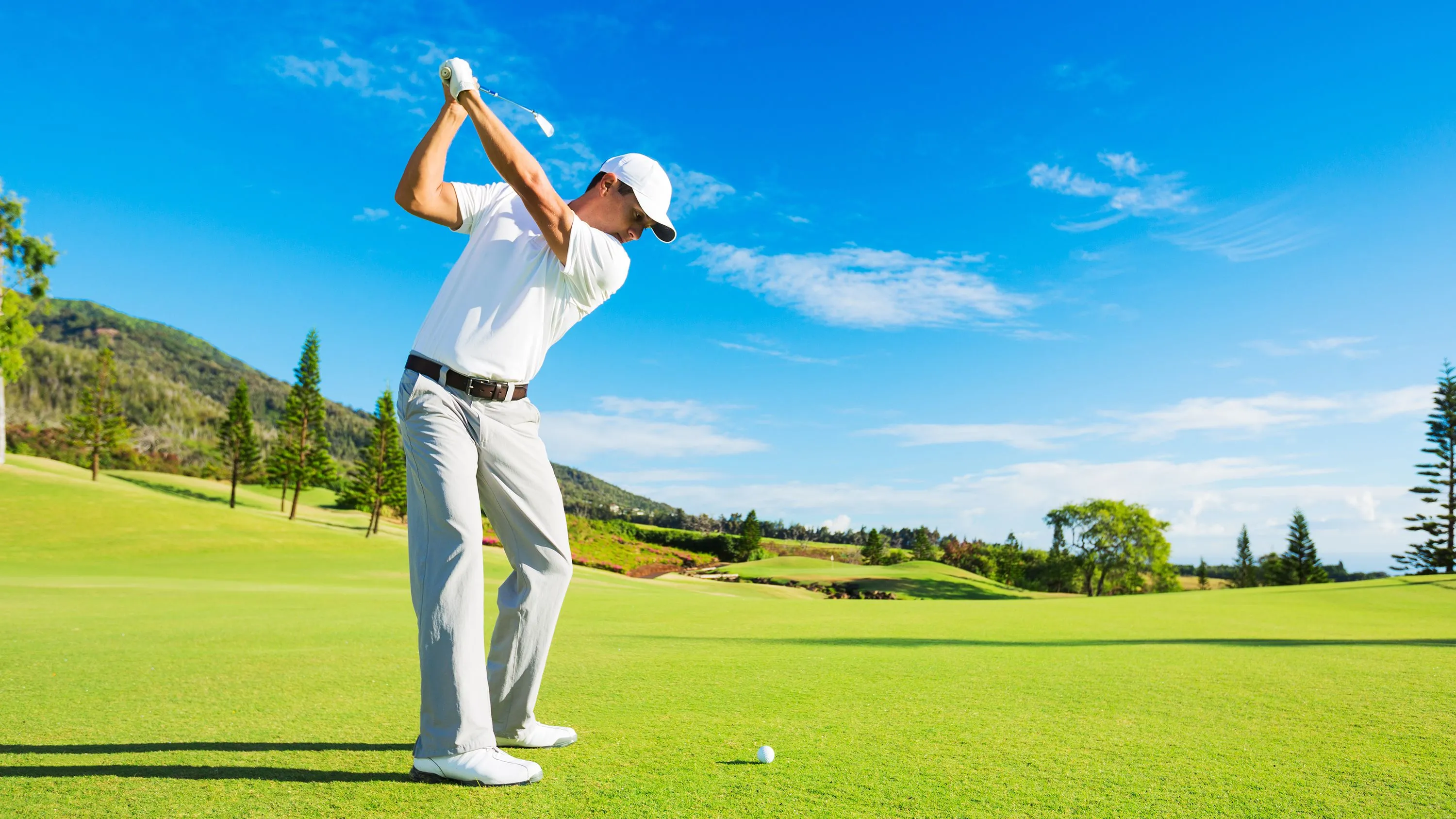 Golfer swings on sunny course, showing active lifestyle supported by Bukaty Family Chiropractic care
