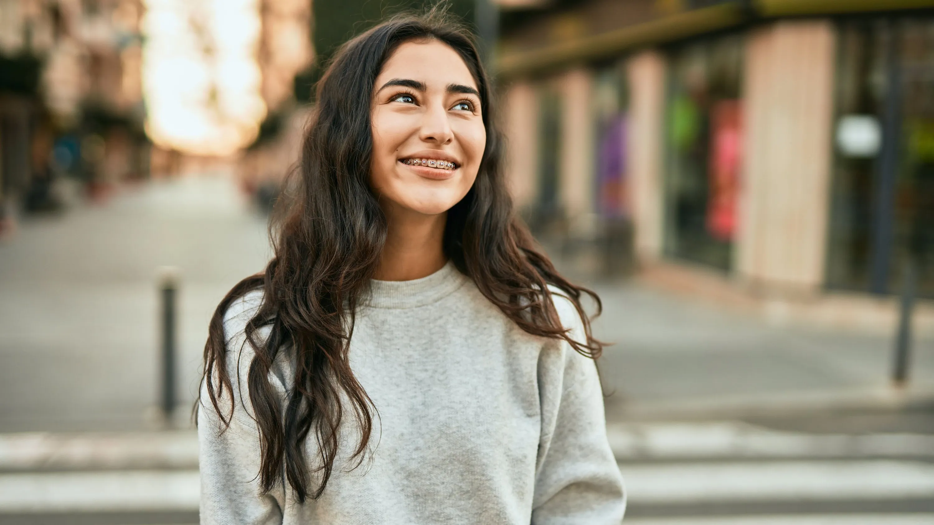 prettygirlwithbrownwavyhairsmilingshowingbraces