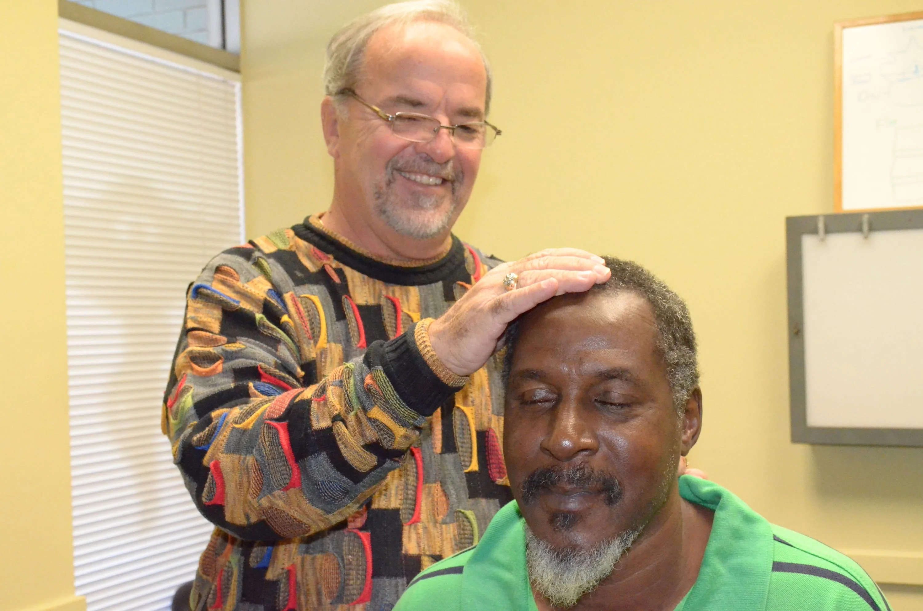 chiropractor adjusting male patient's neck 