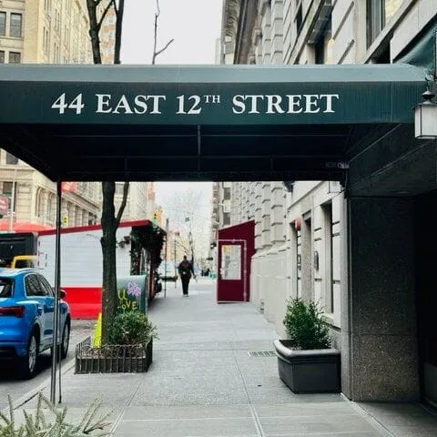 A green awning that reads 44 East 12th Street