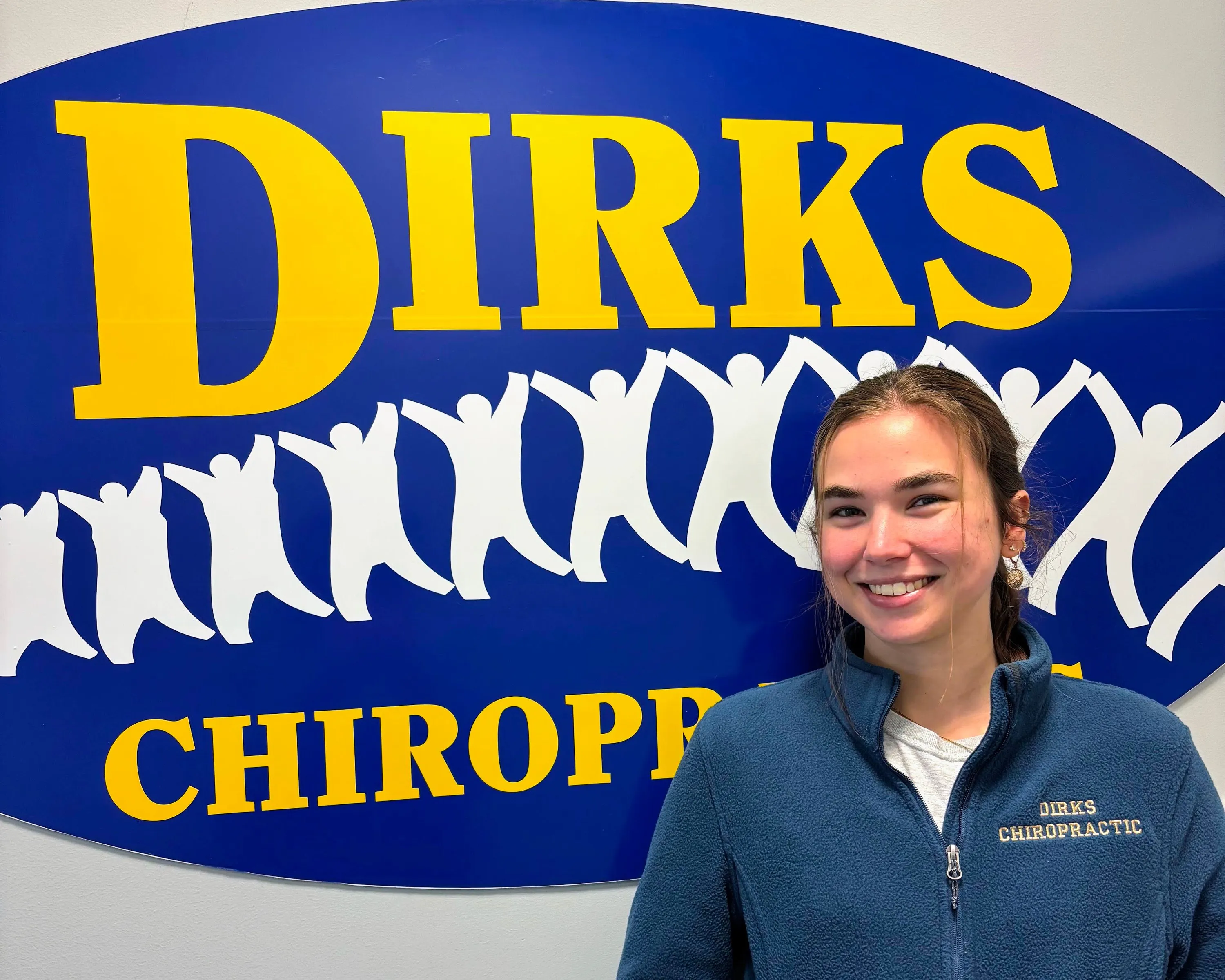 Alex is standing in front of a Dirks Chiropractic Sign