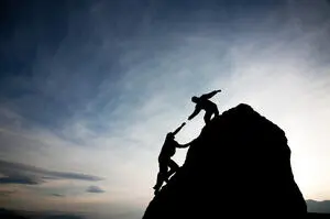 two mountain climbers near the top of a mountain