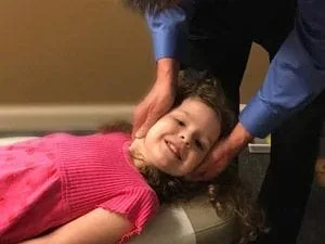 Child receiving a chiropractic adjustment.