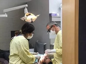 Dr. Warren and assistant tending to male patient with dental emergency Millbrae, CA