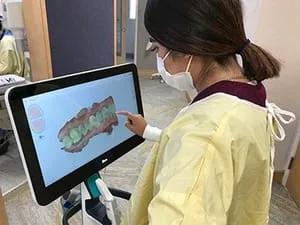 female dental assistant looking at computer image of teeth, restorative dentistry Millbrae, CA dentist