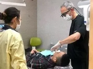 Dr. Warren doing dental work on male patient, kids dentist Millbrae, CA children's dentist