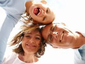 middle aged man, woman, and young girl smiling