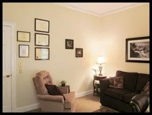 Therapy room in BridgeMill office. Cushioned chair, couche, warm lamp.