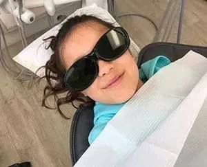 girl in dentist chair wearing black sunglasses, best kids dentist Millbrae, CA