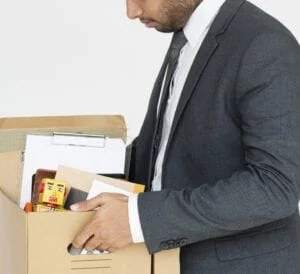 man in suit carrying a box with his personal belongings