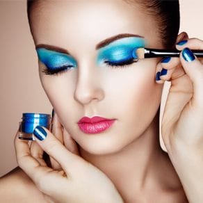 A model having blue makeup applied to her eyelids
