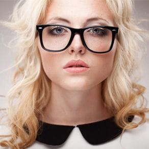 A head shot of a female model wearing large framed glasses