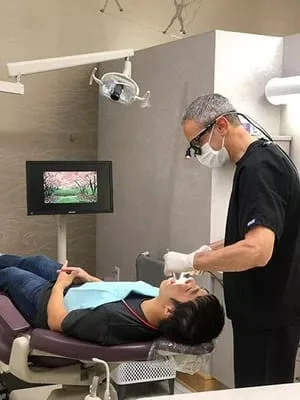 Dr. James Warren performing emergency dental work on male patient, emergency dentist Millbrae, CA