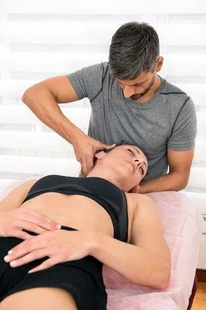 chiropractor adjusting female patients neck 