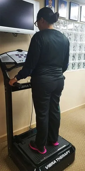woman standing on a Vibro Wave Therapy machine