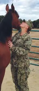 military member standing next to a horse