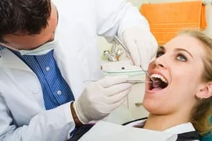 blond woman having mouth examined by male dentist, General Dentistry University City, MO